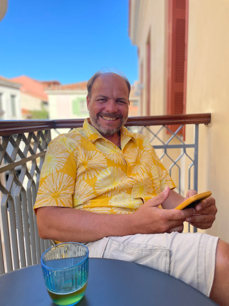 Stefan Spelter auf einem Balkon mit einem Mobiltelephon