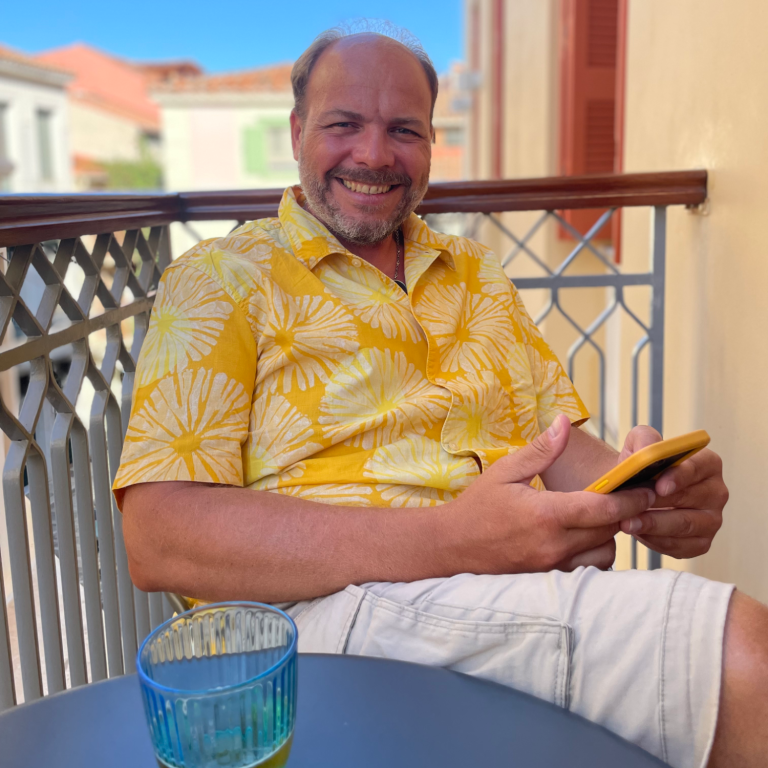 Stefan Spelter auf einem Balkon mit einem Mobiltelephon